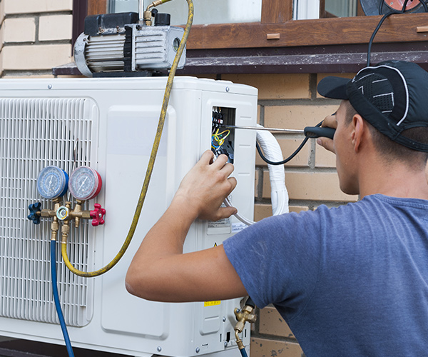 Photo of man repairing a heat pumps